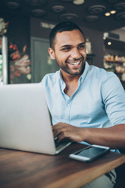istock Young man with laptop in cafe 590037050