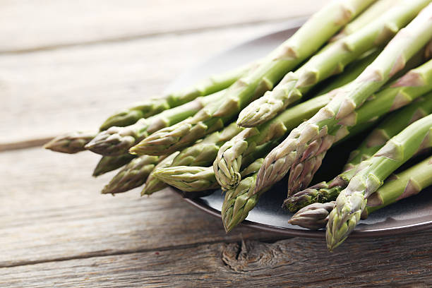 istock Fresh green asparagus on a grey wooden table 590037572