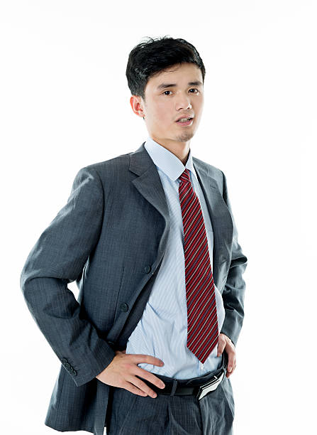 istock Smiling asian businessman standing against white background 590038406