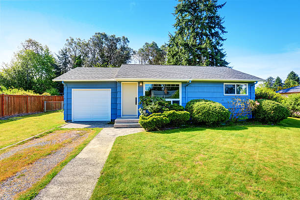 istock Small cute blue house with driveway and trimmed hedges. 590039336