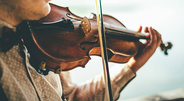 istock Playing violin by the lake 590039774