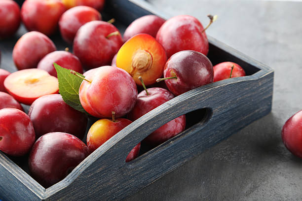 istock Fresh plums on a grey wooden table 590040574