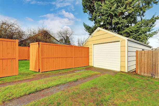 istock Small beige detached garage at the fenced backyard 590040950