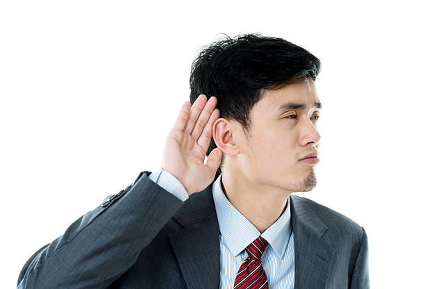 istock Young businessman cupping his ear listening 590041756