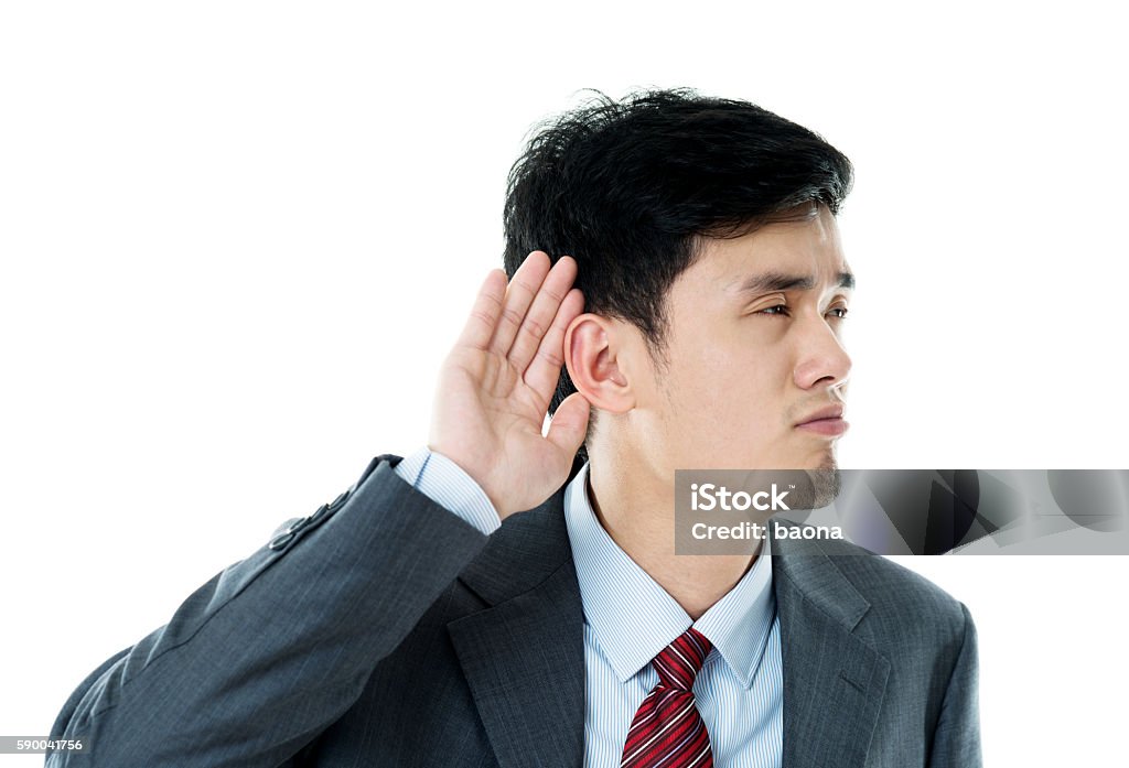 Young businessman cupping his ear listening Young businessman cupping his ear listening. Listening Stock Photo