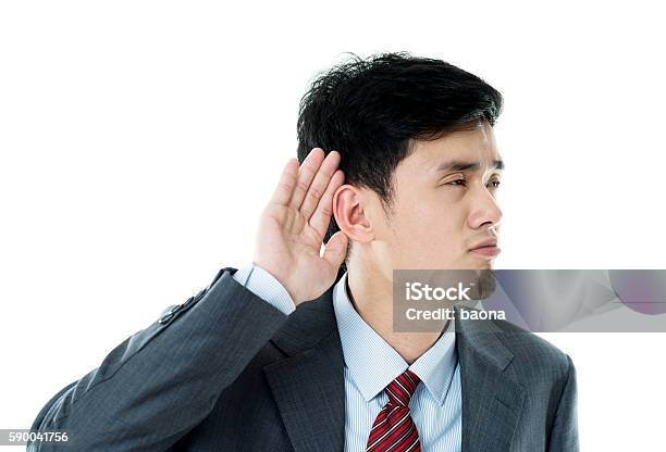 Young Businessman Cupping His Ear Listening Stock Photo - Download Image Now - Listening, Adult, Adults Only