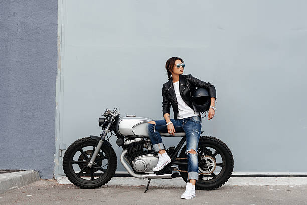 Biker woman in leather jacket on motorcycle stock photo