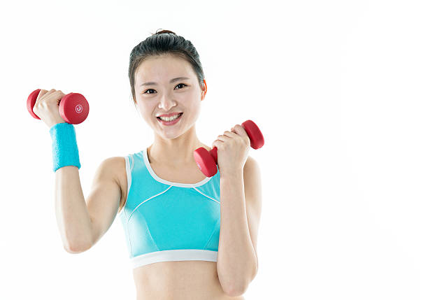 young sport woman exercising with blue dumbbell in the park.