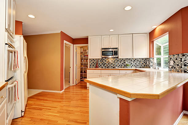 istock White kitchen room with tile counter top and hardwood floor. 590047862