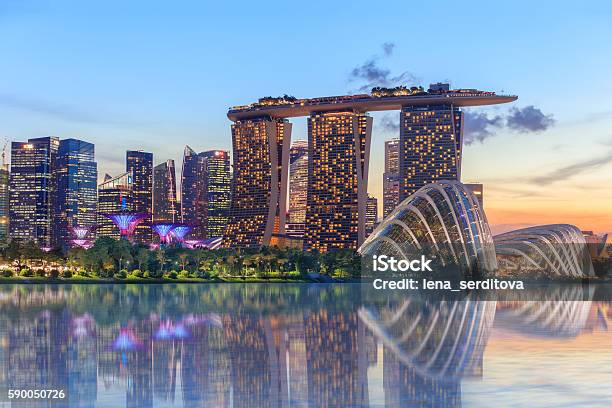 Singapur Brillando Intensamente Por La Noche Foto de stock y más banco de imágenes de Singapur - Singapur, Panorama urbano, Jardines colgantes de la bahía de Singapur