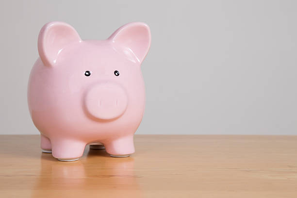 istock Pink piggy bank on wooden table 590052358