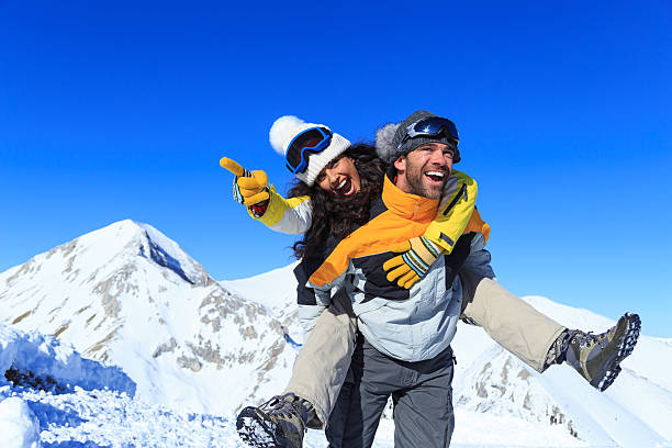 giovani coppia di backpackers che si divertono nella montagna di neve - fun knit hat adult dating foto e immagini stock