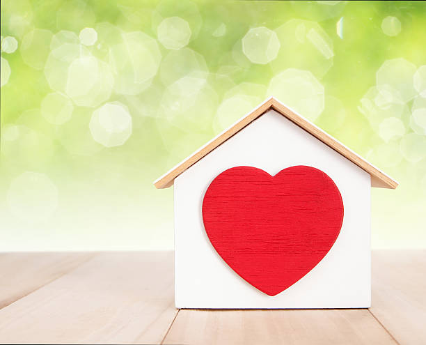 istock Home and red heart on wood with bokeh background 590054938