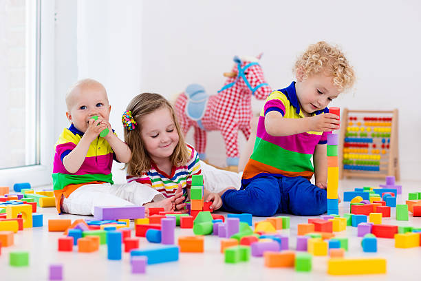 istock Children playing with colorful toy blocks building block tower 590056004