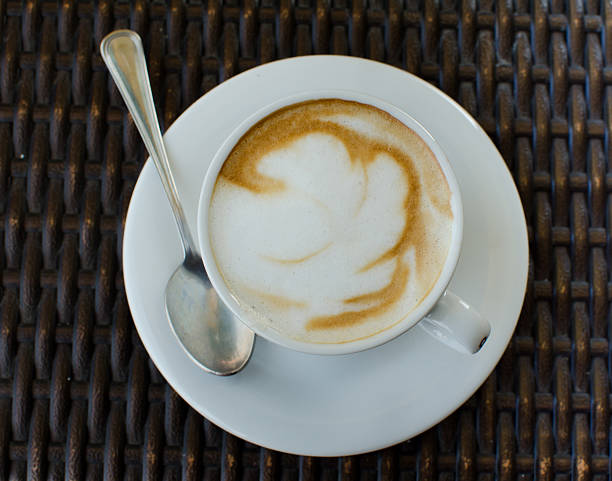 istock The cup of cappuccino on the wicker table. View from above. 590056696
