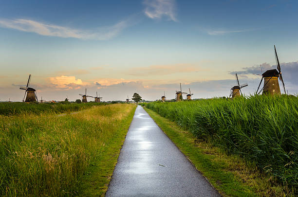 sentier pédestre à travers la campagne des pays-bas au coucher du soleil - polder windmill space landscape photos et images de collection