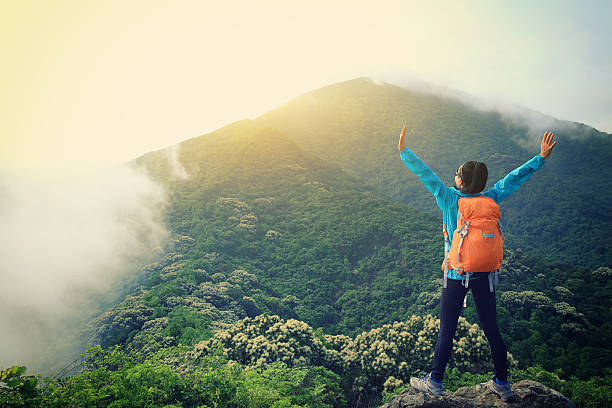 istock cheering young  woman enjoy the view on mountain peak 590058296