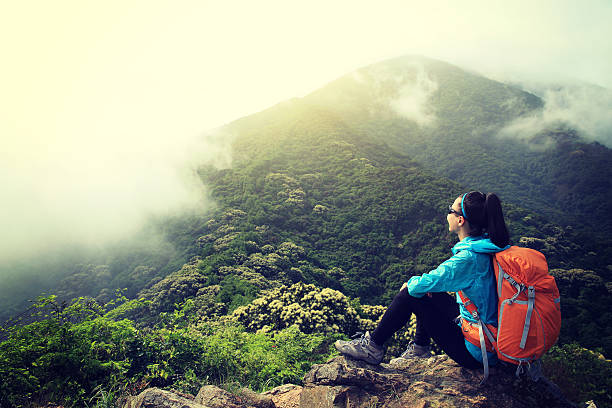 istock young woman backpacker hiking at forest mountain top 590059822