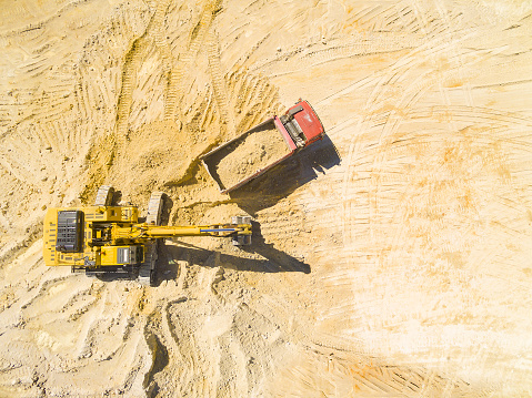 Aerial view of a excavator and truck in the mine. Industrial background on mining theme.