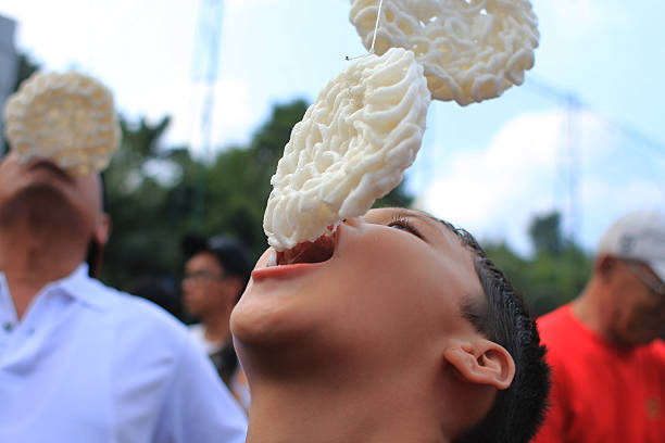 the celebration of the independence of the Republic of Indonesia Jakarta, Indonesia - August 17, 2016: Residents enthusiastically celebrating the independence of Indonesia with various competitions.. Located at Gelora Bung Karno, organized various competitions, cracker eating contest , palm climbing.  There are  present many exciting prizes. eating child cracker asia stock pictures, royalty-free photos & images