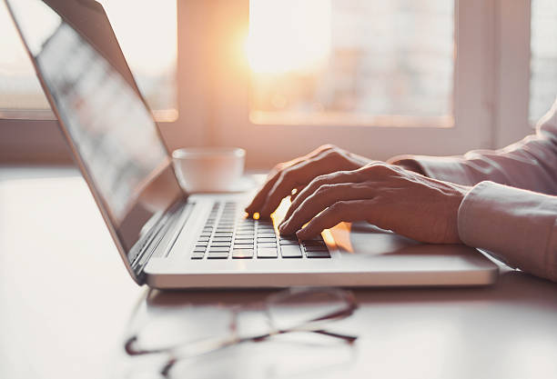 hombre usando computadora portátil  - typing fotografías e imágenes de stock