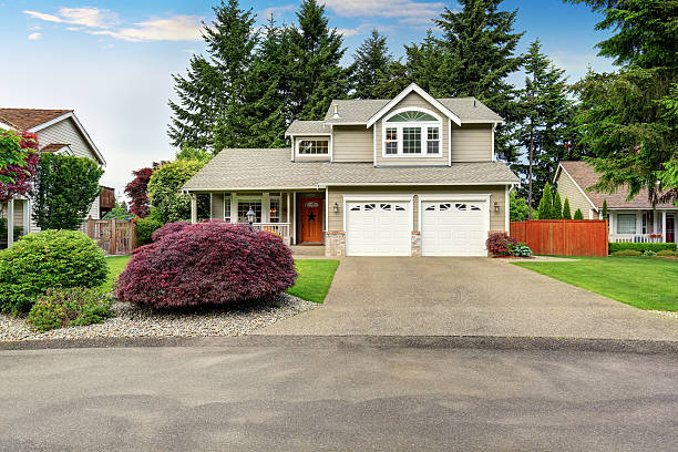 istock American house exterior with double garage and well kept lawn. 590062332