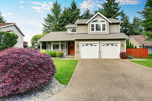 istock American house exterior with double garage and well kept lawn. 590062436