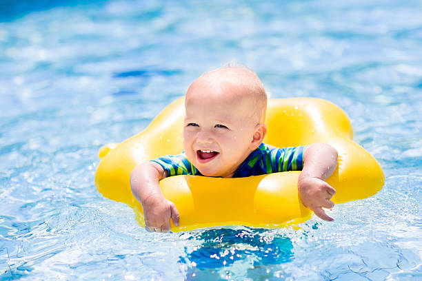 istock Little laughing baby in swimming pool 590062610