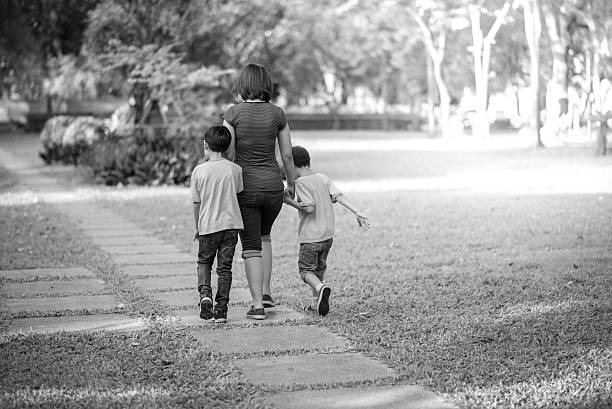 single mother walking in the park with sons