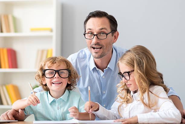 istock Family sitting at table and drawing 590063654
