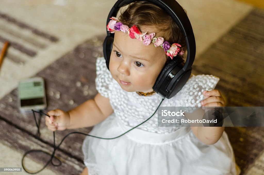 baby listening to music on headphones baby listening to music on headphones, a little girl singing and listening to the radio Arts Culture and Entertainment Stock Photo