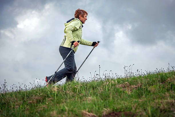 Mature Woman Nordic Walking on Plateau, Slovenia, Europe Mature woman Nordic walking with hiking poles on the Banjšice plateau in spring, Primorska region, Alps, Slovenia, Europe. Nikon D3x, full frame, XXXL. northern european descent stock pictures, royalty-free photos & images