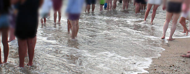 たくさんの足がビーチに立っている - flip flop human foot sand women ストックフォトと画像