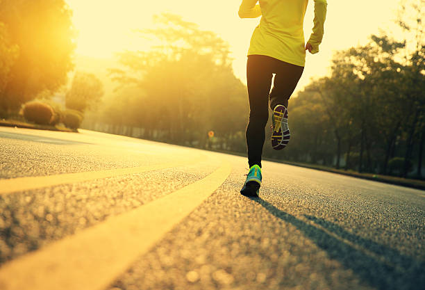 jovem aptidão mulher de corredor correndo na estrada - running jogging road exercising - fotografias e filmes do acervo