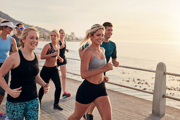 istock Young people running along a seaside promenade 590070922