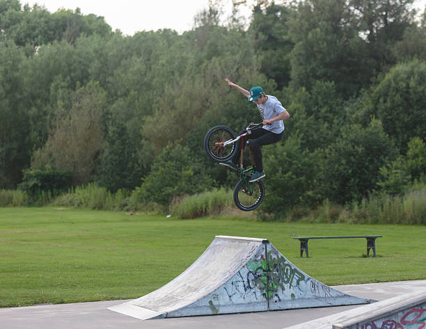 BMX rider jumping over spine in Skate Park stock photo