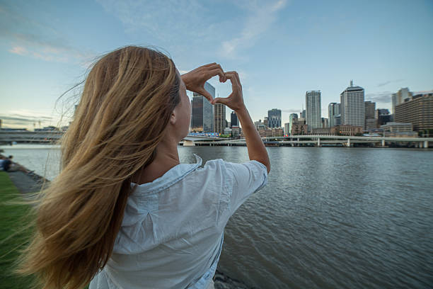 istock Caucasian female makes heart shape finger frame to Brisbane 590071470