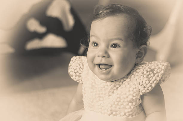 istock beautiful little baby one year sitting on a carpet 590072234