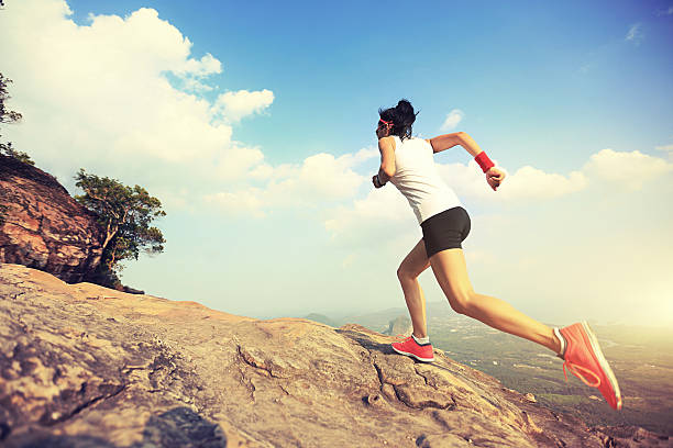 istock young asian woman runner running on mountain peak 590073458