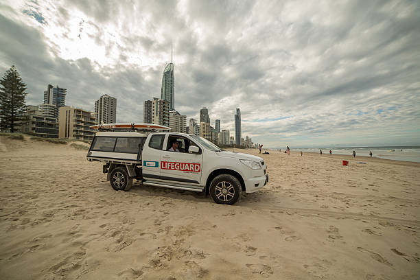 サーファーのパラダイスビーチでライフガード車 - gold coast australia lifeguard sea ストックフォトと画像