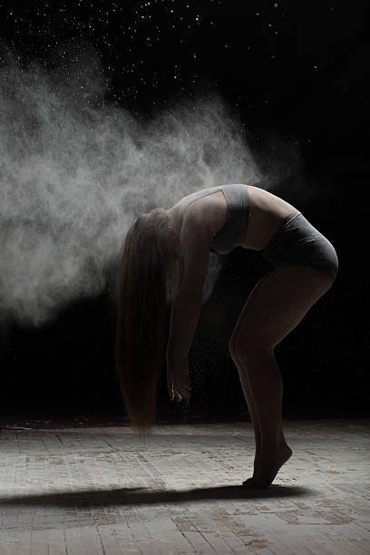 istock Flexible woman posing with flour on black background 590075930
