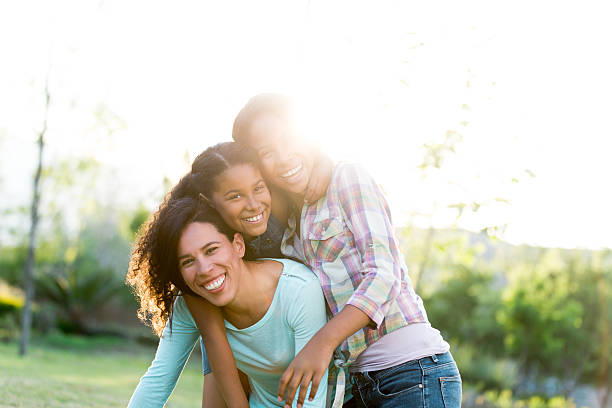 istock Joyful mother and daughters smiling outdoors in backlight 590076218