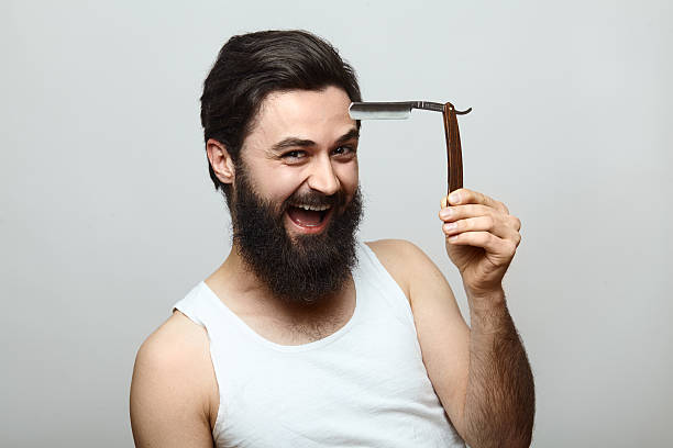 istock Sexy handsome young man with a shaving razor 590076956