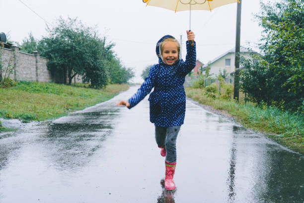 A young boy outside in the rain