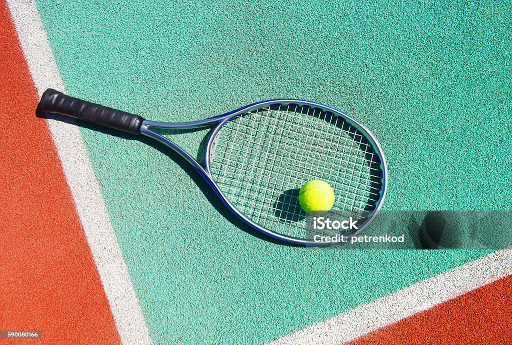 Close up of tennis racquet and ball on court Close up of tennis racquet and ball on the clay tennis court Tennis Racket Stock Photo
