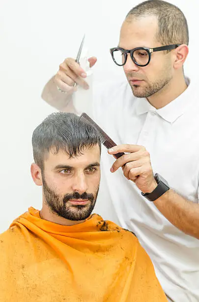 Photo of hairdresser cuts a customer piece of hair