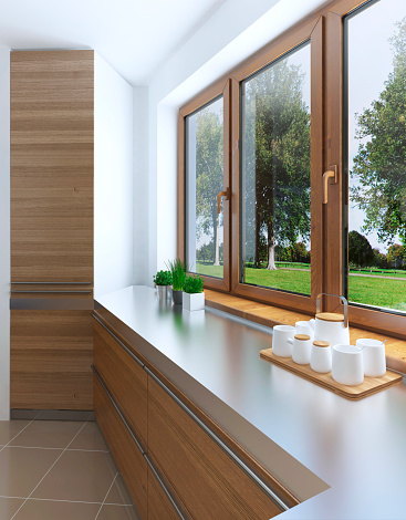 The design idea of the built-in refrigerator in the facade of a modern kitchen. A large window smoothly passing into the kitchen countertop. Facades of light wood. 3D render.