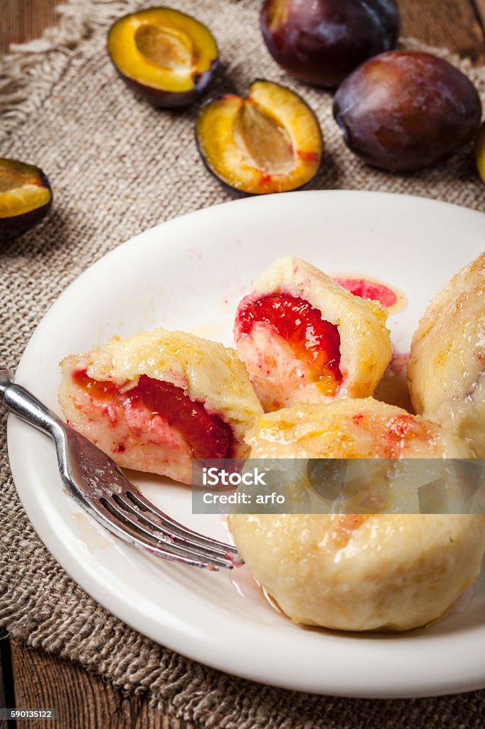 Sweet plum dumplings. Sweet plum dumplings in metal bowl on wooden table. Austria Stock Photo