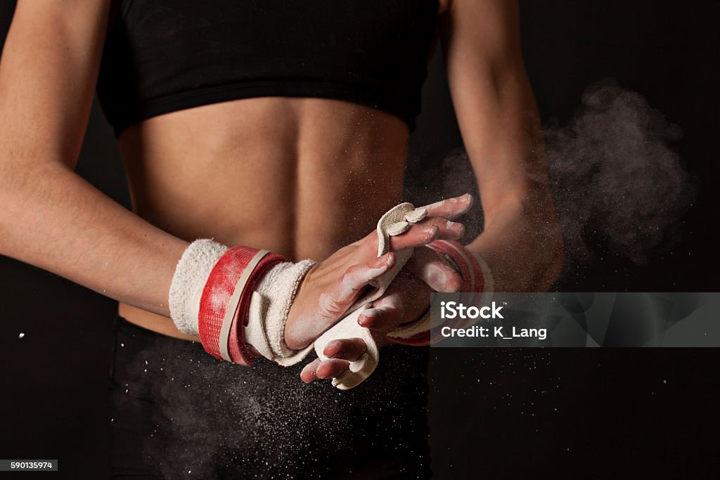 Gymnaste artistique crayant des poignées pour les barres inégales - Photo de Gymnastique artistique libre de droits