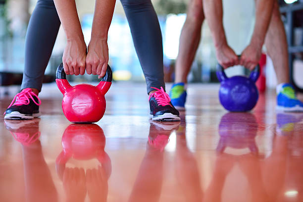istock Kettlebells swing exercise man and woman workout at gym 590138698